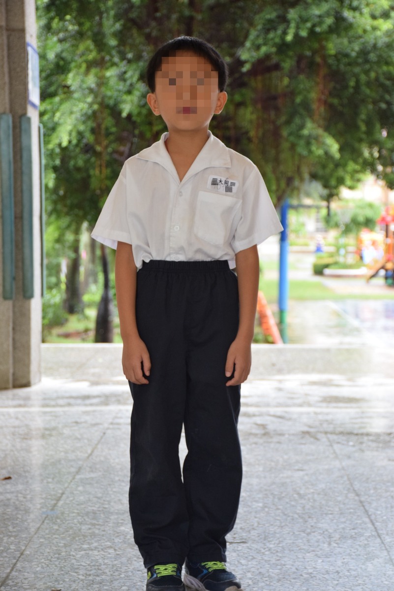 男生制服（褲裝）穿著式樣，學號牌繡於左胸口袋上方，男生亦可穿制服深藍色短褲圖片