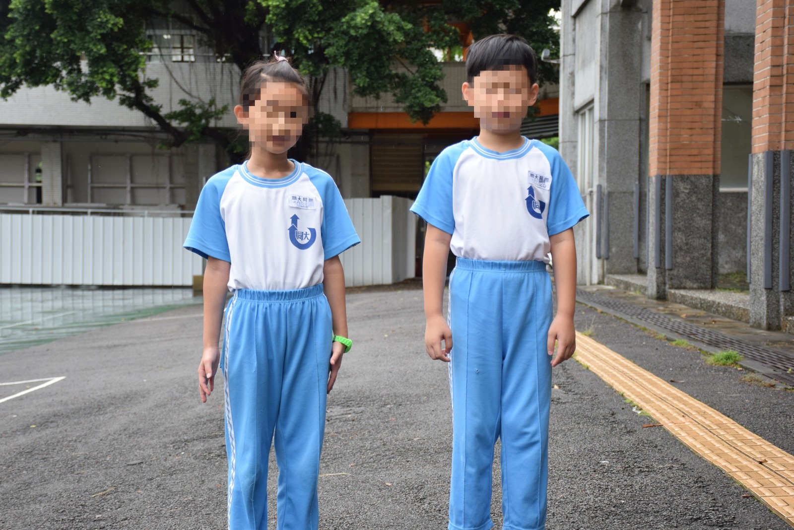 男生與女生體育服穿著式樣，學號牌繡於左胸大同圖標上方，男生與女生亦可穿著藍色運動短褲